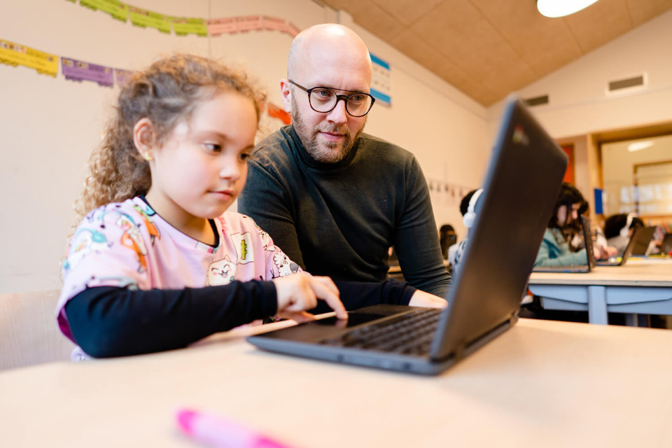 Leekracht en meisje achter laptop in de klas